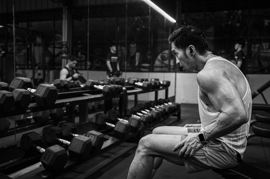 A man sitting on a bench in a gym