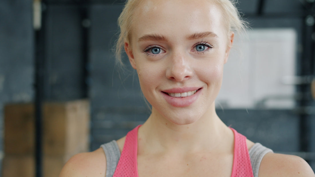 A smiling blonde woman in fitness attire.