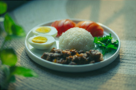 Plate of rice, eggs, meat, and vegetables